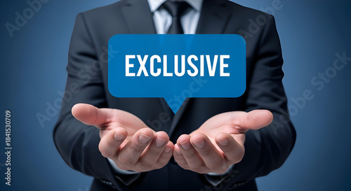 Businessman presenting the word exclusive in a blue speech bubble held over open hands against a dark blue background symbolizing special access or offer