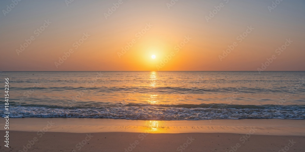 Fototapeta premium Golden sunset colors reflecting on the sea water surface, suitable as a background for travel websites, summer scenes, and nature themes