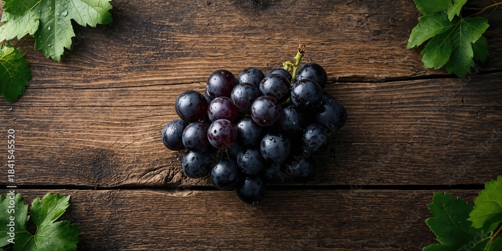 Fototapeta premium Close-up of black grapes on rustic wood highlighting fruit surface details for culinary display