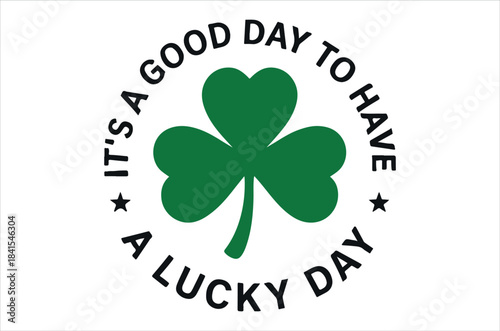 A circular design features a vibrant green clover encircled by a cheerful message of good luck and positivity