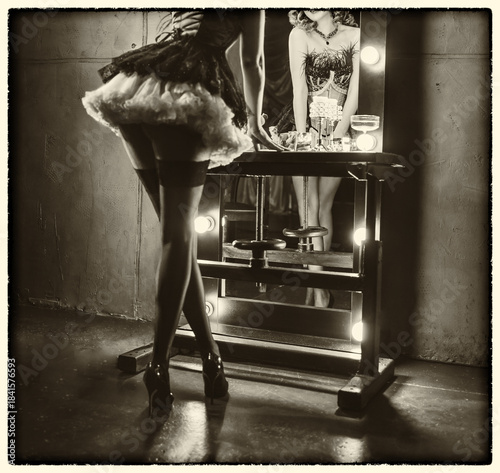 art sepia black and white color, retro lady long legs short dress stockings high heels back rear view looking into mirror vintage lamps. sexy woman burlesque show dancer actress flapper girl 20s roar