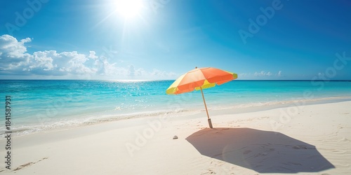 Fototapeta Naklejka Na Ścianę i Meble -  Beach umbrella near the blue ocean, serving as a backdrop for leisure activities