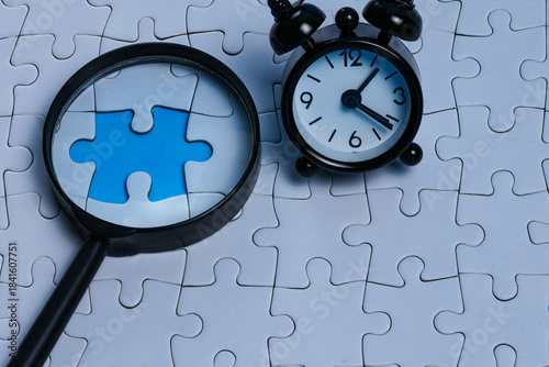 Tableau sur toile A magnifying glass focusing on a missing puzzle gap with a mini alarm clock placed beside it, representing problem solving and identifying key concepts before a deadline