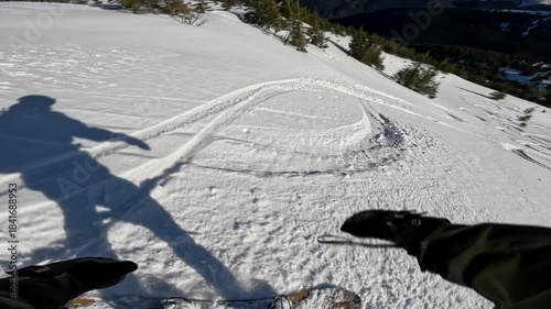 First person view of fast backcountry snowboarding downhill, carving tracks in powder snow,sunny day