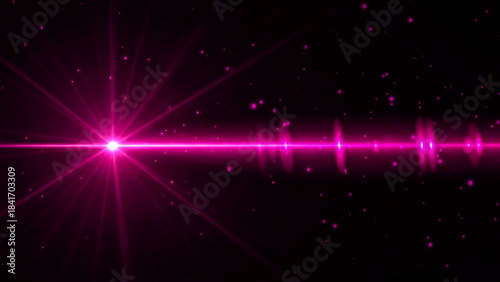 A vibrant pink starburst lens flare dominates the left side of the frame, emitting radiant beams across a dark background. Small, glowing pink particles, resembling stars or bokeh, are scattered