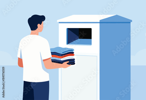 Man holding stack of folded clothes near a dispensing unit