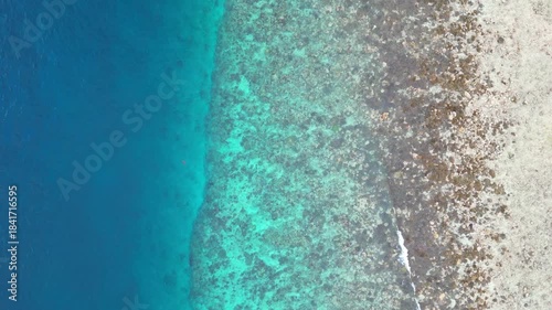 Tropical clean ocean aerial view by drone. Gili Island beach shore coastline showing different shades of sea water in Lombok, Bali, Indonesia