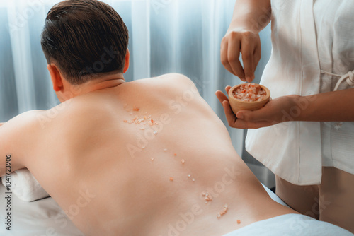 Принти на полотні Blissful man customer having exfoliation treatment in luxury spa salon with warmth candle light ambient