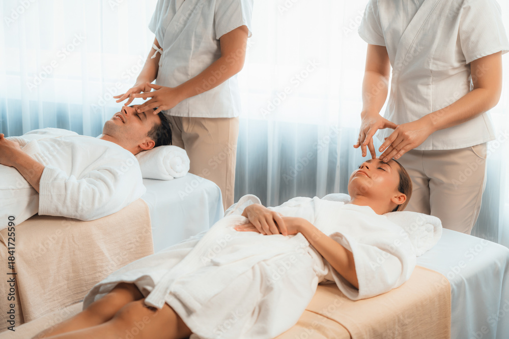 Obraz premium Caucasian couple enjoying relaxing anti-stress head massage and pampering facial beauty skin recreation leisure in dayspa modern light ambient at luxury resort or hotel spa salon. Quiescent