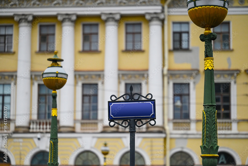 Naklejka premium Street sign and street lanterns on building background