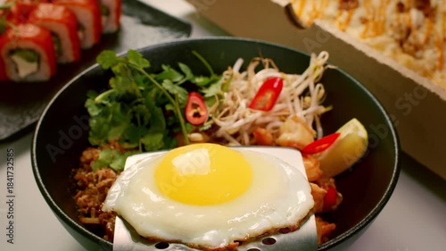 A fried egg is carried from the pan to the plate