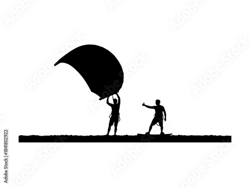 Silhouettes of two people preparing a kite for watersports activity.