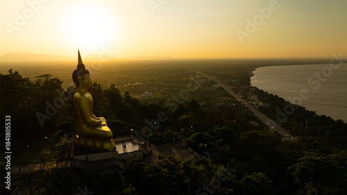 Aerial view at sunset above the Mekong river in Laos revealing Pakse city golden giant buddha