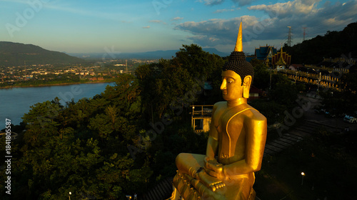 Aerial view at sunset above the Mekong river in Laos revealing Pakse city golden giant buddha