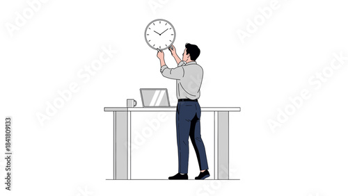A man hanging a clock on the wall above a desk with a laptop and a mug in an office