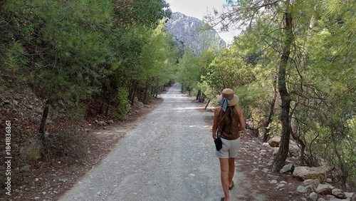A woman walks along a mountain path in Goynuk Canyon, Turkey. Hiking the scenic road leading towards Goynuk Gorge.