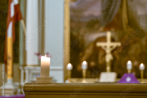 Foto Single Burning Candle in Sacred Church Interior with Blurred Crucifix and Lit Al