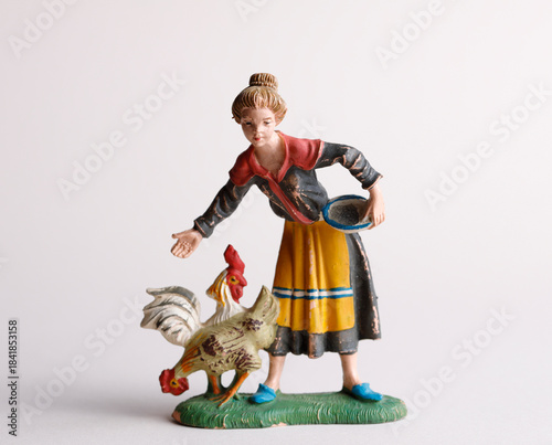 Antique small figurine: women feeding chickens