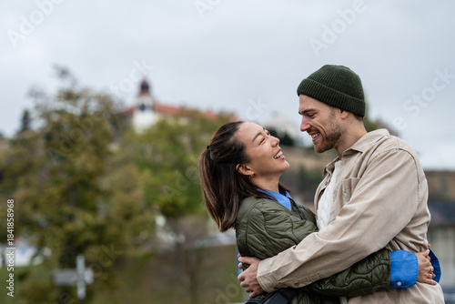 Foto Happy multiracial couple embracing outdoors and laughing