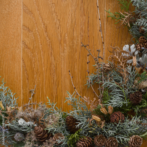 Winter decoration of cypresses, fern, silver ragwort, and cones from various conifers on the wooden background