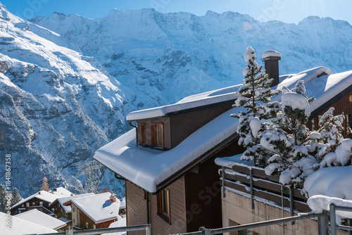 Fresh winter snow covering the alpine village and surrounding peaks, creating a bright and peaceful mountain landscape