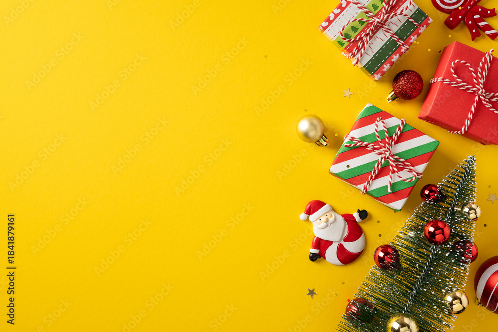 Fototapeta premium Vibrant vertical holiday scene with wrapped gifts, a Santa ornament, a Christmas tree, and festive decor on a sunny yellow backdrop, ideal for holiday promotion and greeting materials