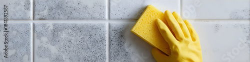 Woman in yellow glove cleaning black mold and fungus on bathroom tile with sponge and soap foam for home health.