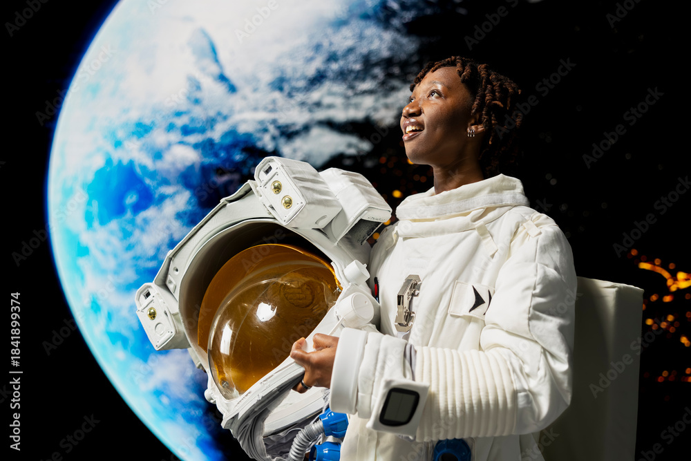 Obraz premium Pleased orbital station astronaut holding helmet amazed by beauty of planet in space. Joyful woman wearing cosmonaut gear astonished by galaxy celestial bodies during planetary exploration mission