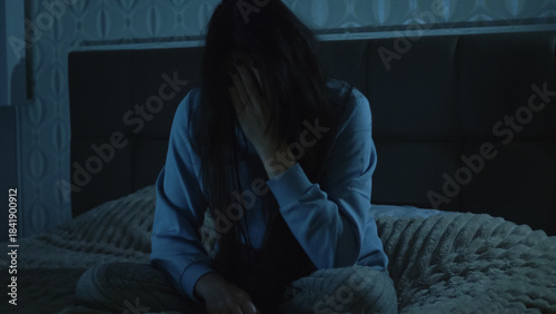 A young woman sits on her bed at night, overwhelmed and unfocused. Her foggy mind and emotional exhaustion reflect insomnia, inner struggle, and mental disorientation. 
