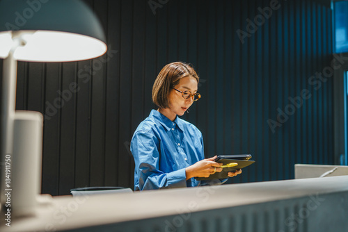 Woman designer reading sample book in modern office