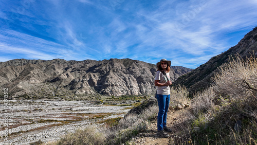 A Woman Geologist on the Trail in the Whitewater Canyon in California evaluating weathering, Erosion, and Runoff along the Whitewater River near Palm Springs to evaluate flood potential