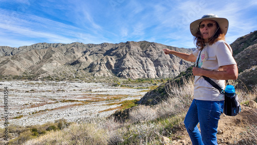 A Woman Geologist on the Trail in the Whitewater Canyon in California evaluating weathering, Erosion, and Runoff along the Whitewater River near Palm Springs to evaluate flood potential