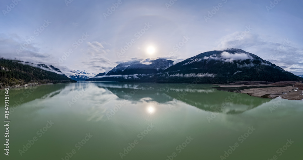 Naklejka premium Panoramic Mountain Lake Landscape in British Columbia With Misty Peaks and Calm Green Water
