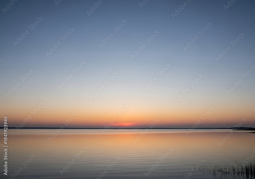 Naklejka premium Tranquil water reflection captures the peaceful sunset in a serene scene