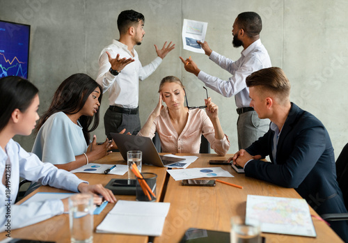 Фотография In a bright, modern boardroom, a group of stressed business people are having a disagreement