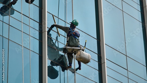 Professional Window Cleaner Washing a Modern Skyscraper Facade