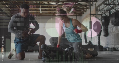 Boxing coach starting wrist timer and cuing trainee hitting low heavy bag, overlay timing for form