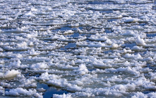 Ice floes float on a frozen river on a sunny winter day. Ice has formed on the Neris River in eastern Lithuania.