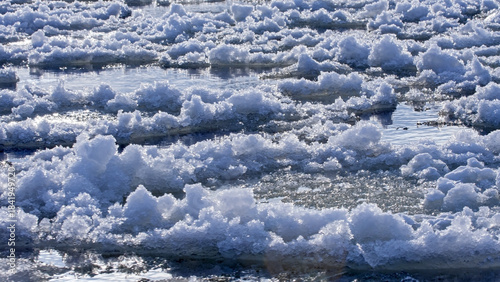 Ice floes float on a frozen river on a sunny winter day. Ice has formed on the Neris River in eastern Lithuania.