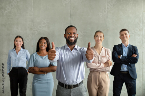 Φωτογραφία A happy group of employees poses with a smiling Black male CEO in a contemporary office