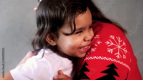 Happy latin mother and child daughter having tender moment during Christmas time. Family love relationship