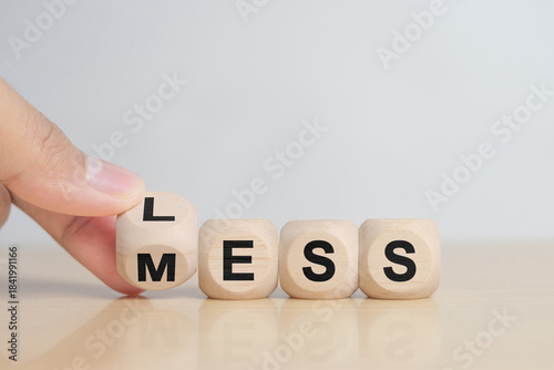 hand hold Less mess words on wooden blocks.