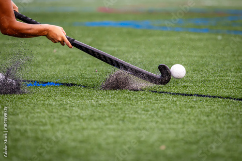 Photography Shooting the ball in a field hockey game sends turf rocks flying on impact