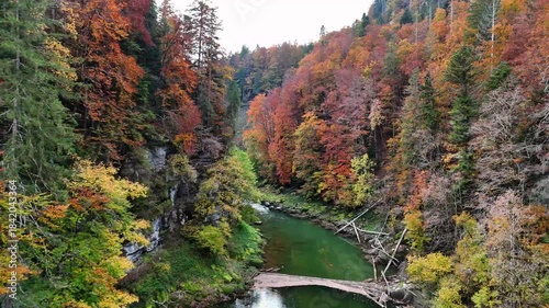 River Doubs as it approach the waterfalll, flows through deep gorge on the border between France and Switzerland within the Jura Mountain,Franche-Comté region, displaying vibrant autumn foliage
