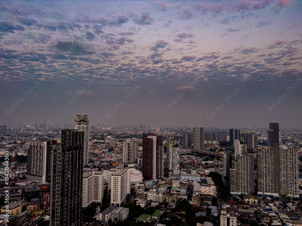 Obraz premium 13 December 2025 colourful sunset with fluffy white pink purple orange and blue skies over the city towers of BKK Bangkok Thai Thailand