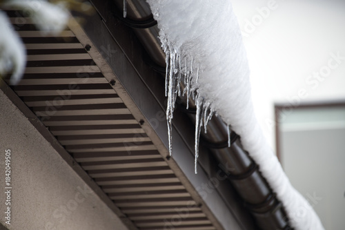 Icicles Hanging From Snow-Covered Roof Edge Create Winter Chill and Quiet Morning Atmosphere