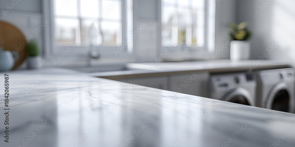 Fototapeta premium A modern kitchen interior highlighting a sleek marble countertop with laundry machines visible in the background. Ideal for home decor.