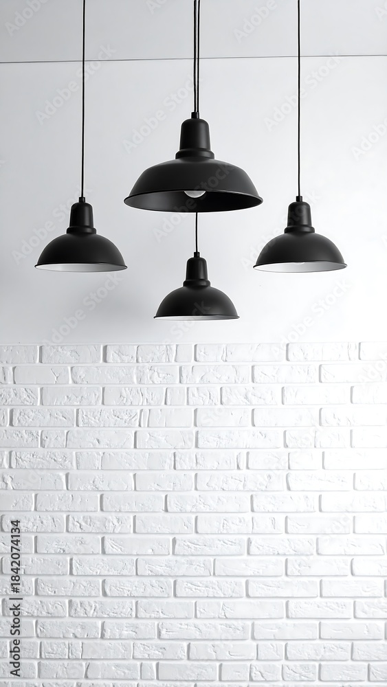 Obraz premium Four black pendant lights hang over a white brick wall, minimalist interior shot