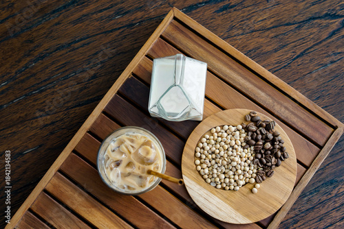 Cuadro en lienzo Top-down shot of coffee beans, soybeans, soy milk, and an iced latte arranged on