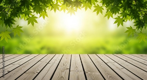 Vibrant green leaves and bright sunlight illuminate a natural bokeh background above a textured wooden deck, providing an idyllic springtime or summer setting for creative displays